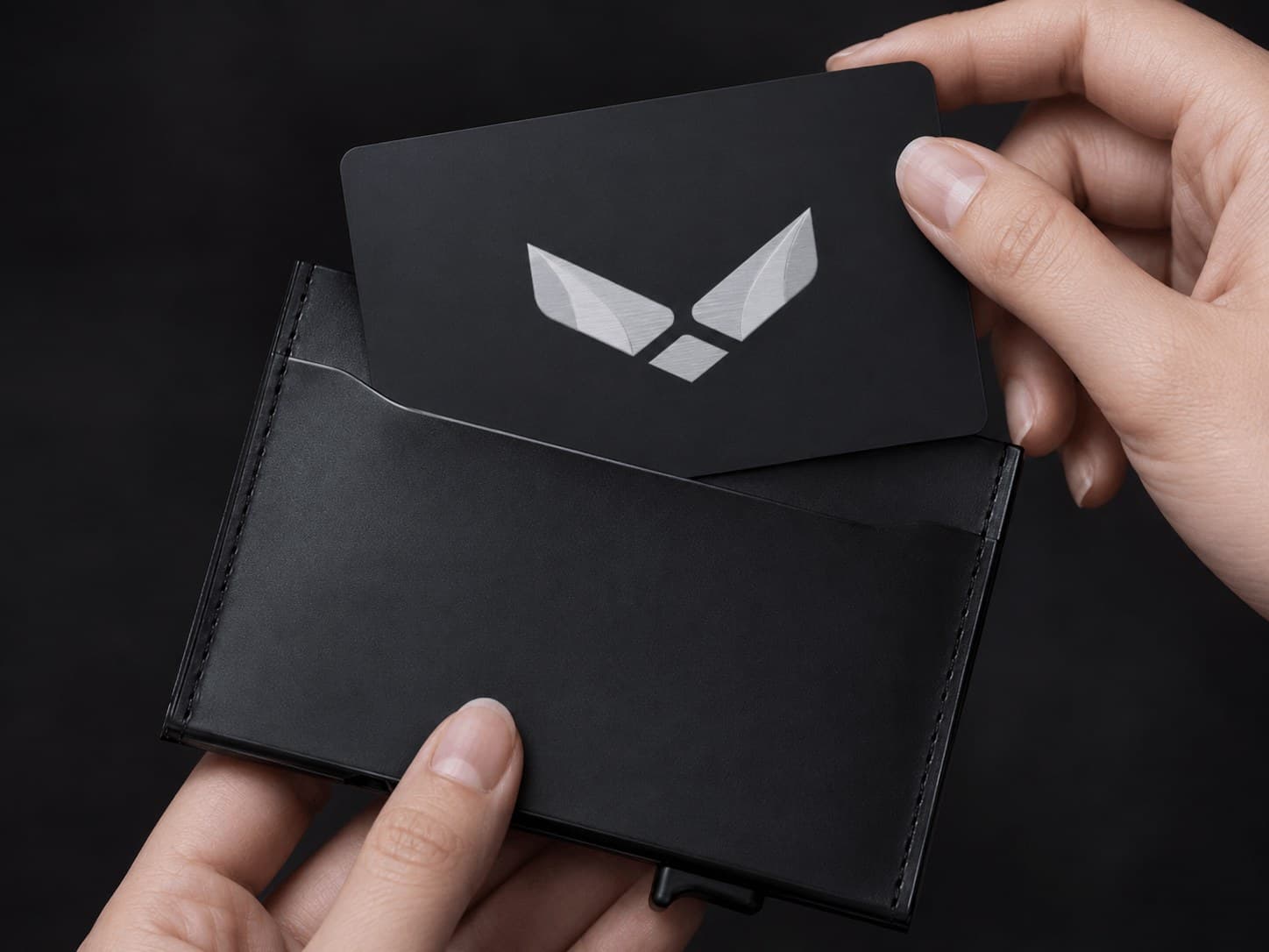 The metal card being drawn from a leather wallet